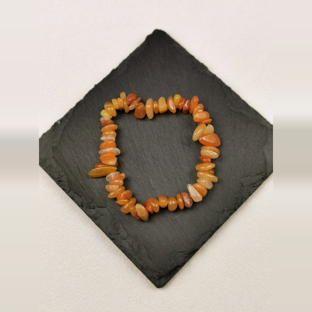 Armband aus Karneolsplittern in Orange- und Honigtönen auf Schieferplatte