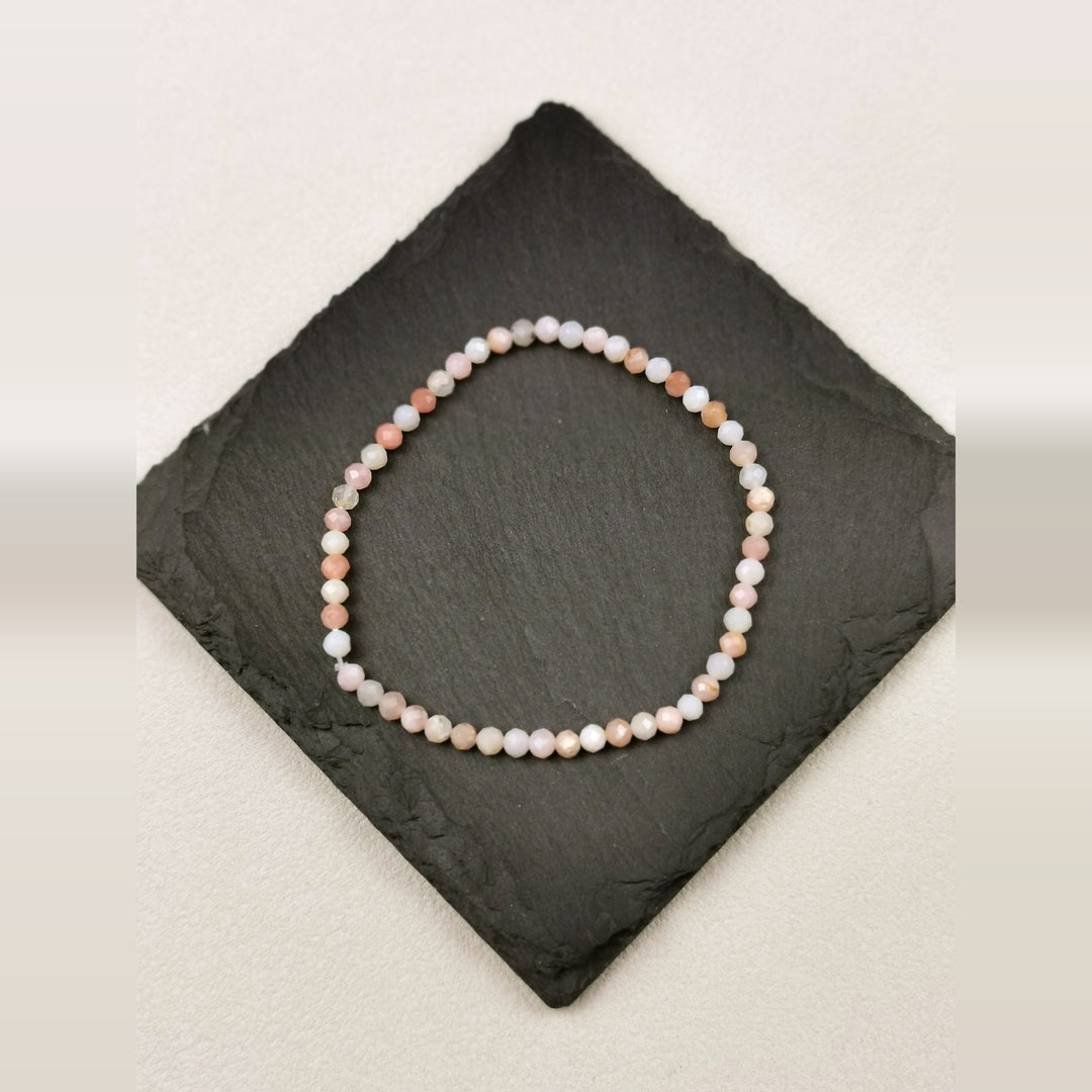 Armband aus facettierten Andenopalperlen in Rosé und Apricot mit 4 mm auf Schieferplatte