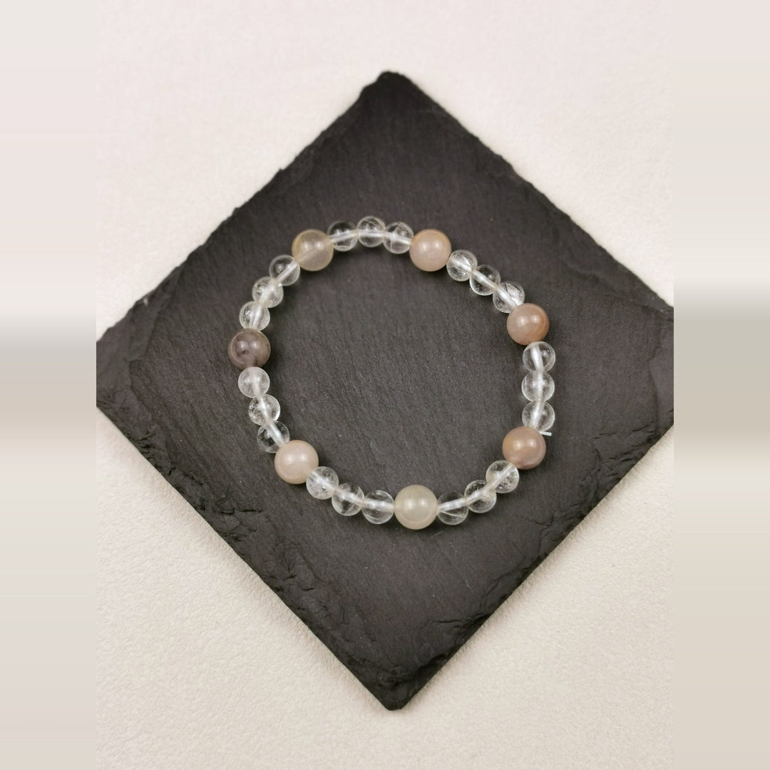 Armband aus klarem Bergkristall mit Pfirsich-Mondstein auf Schieferplatte