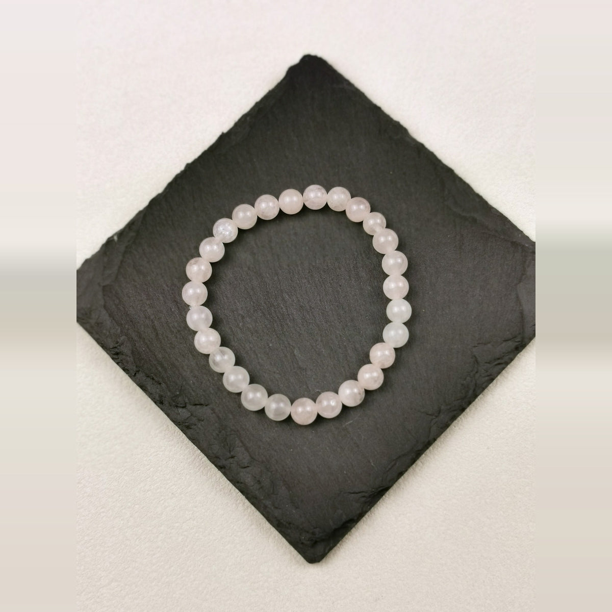 Armband aus runden Rosenquarzperlen mit 6 mm auf Schieferplatte