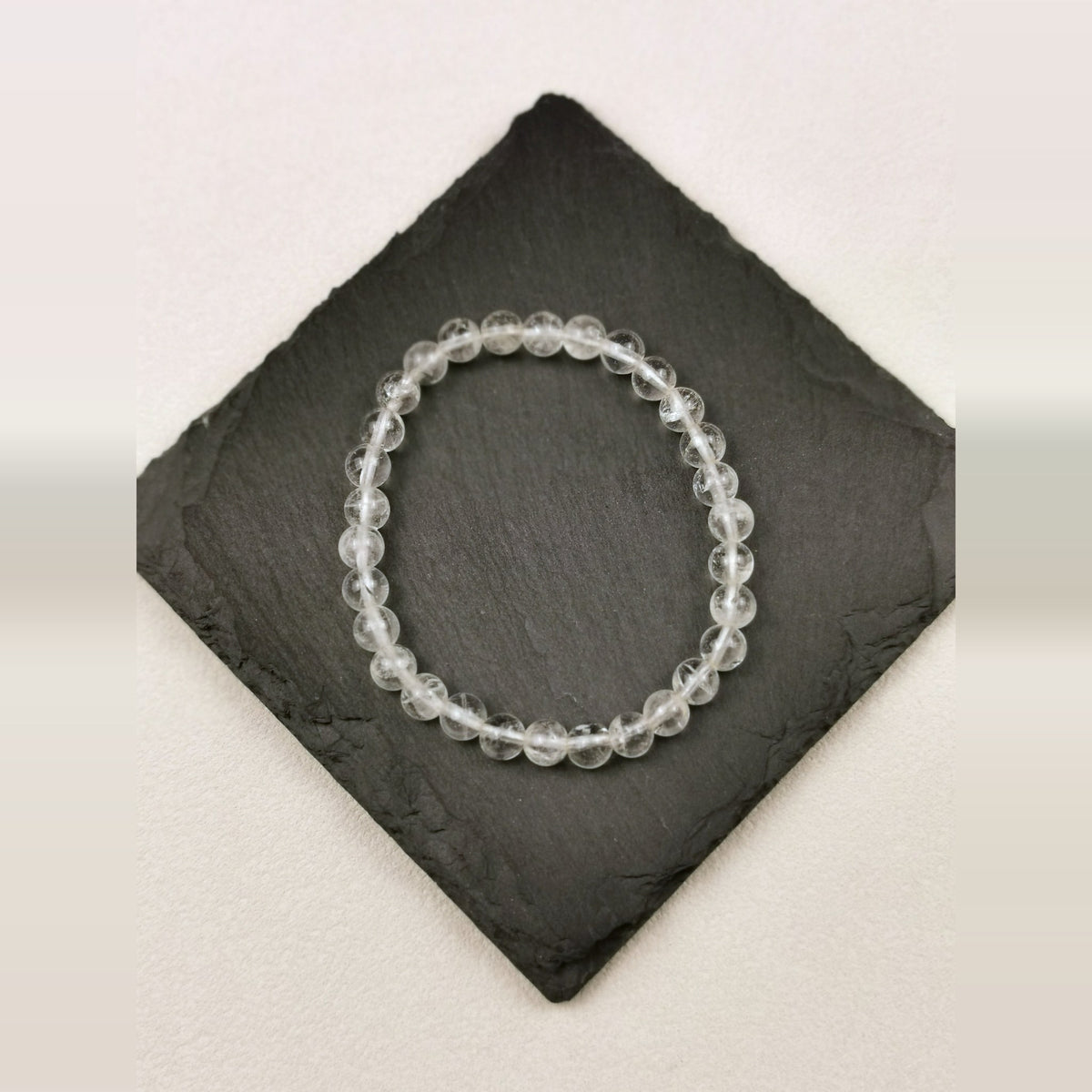 Armband aus runden klaren Bergkristallperlen mit 6 mm auf Schieferplatte