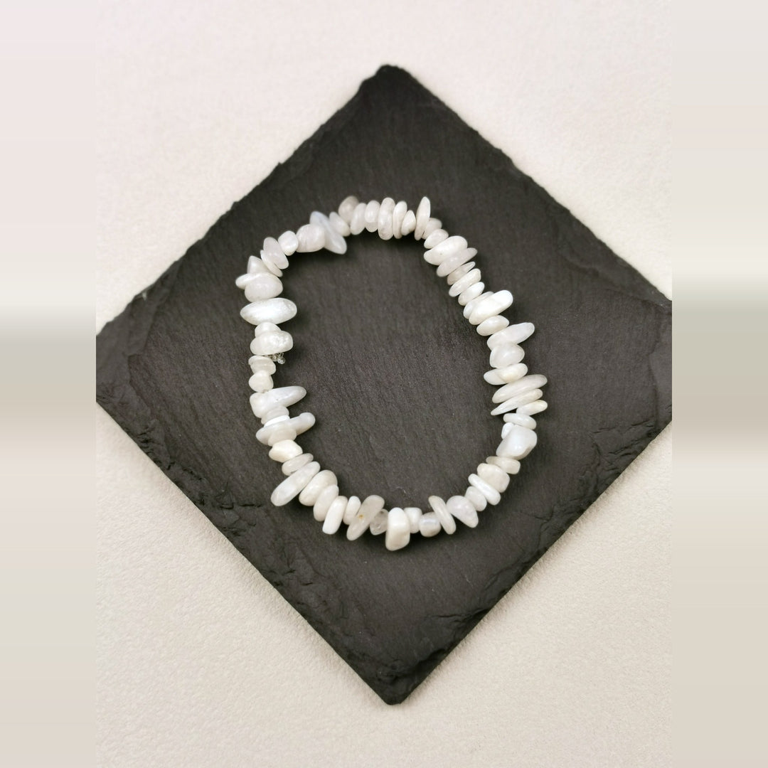 Armband aus cremeweißen Mondsteinsplittern auf Schieferplatte