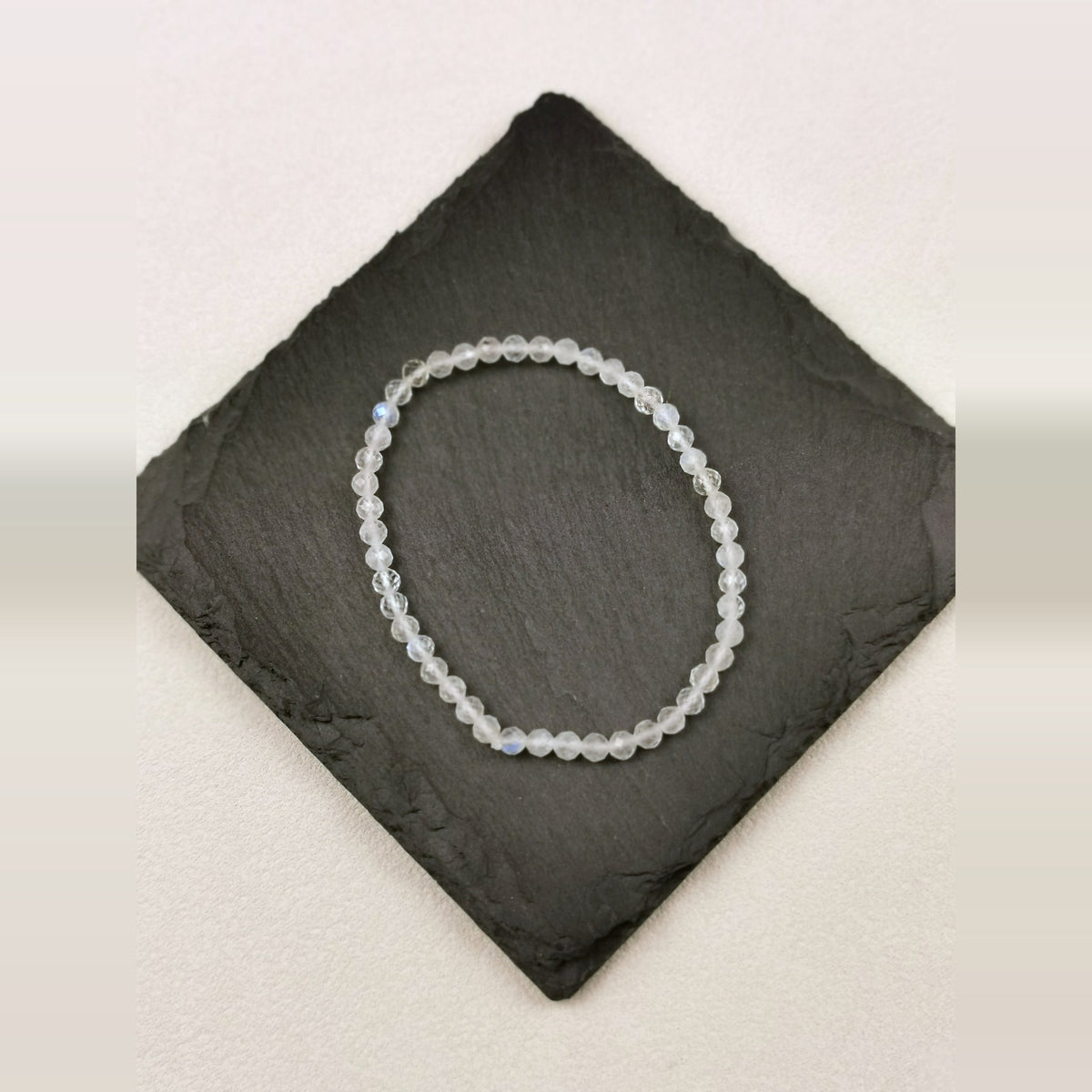 Armband aus facettiertem blauem Mondstein mit 4 mm auf Schieferplatte