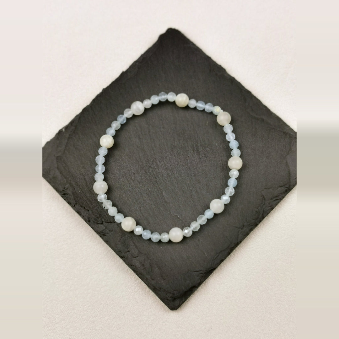 Armband aus facettiertem Aquamarin mit weißen Mondsteinkugeln auf Schieferplatte