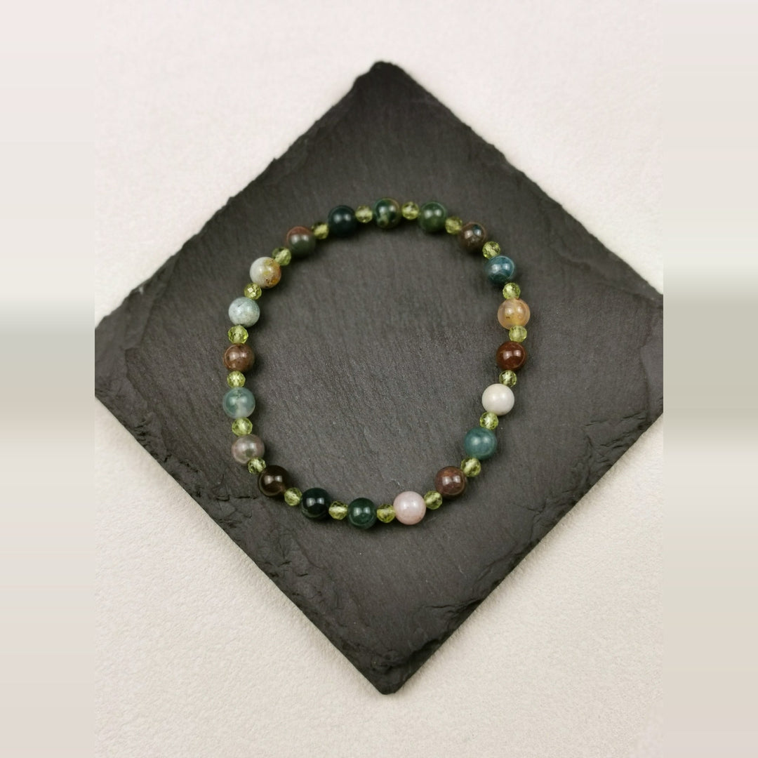 Armband aus gemustertem Moosachat mit facettierten Peridotperlen auf Schieferplatte