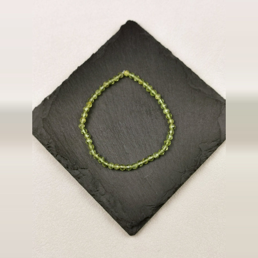 Armband aus facettierten olivgrünen Peridotperlen mit 4 mm auf Schieferplatte