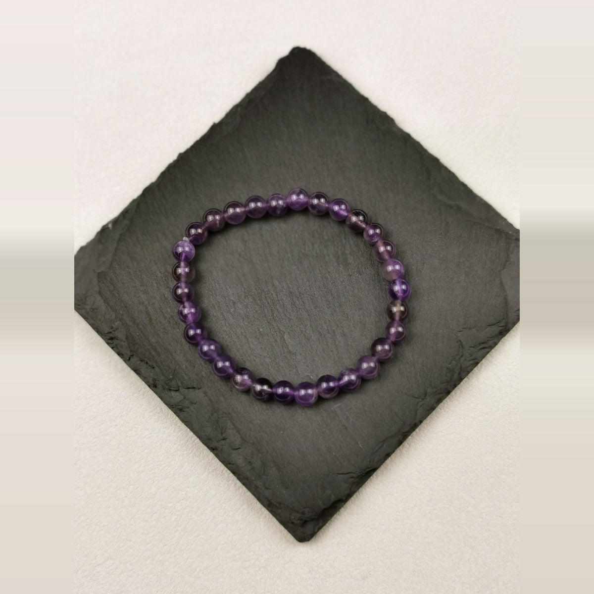 Armband aus runden violetten Amethystperlen mit 6 mm auf Schieferplatte