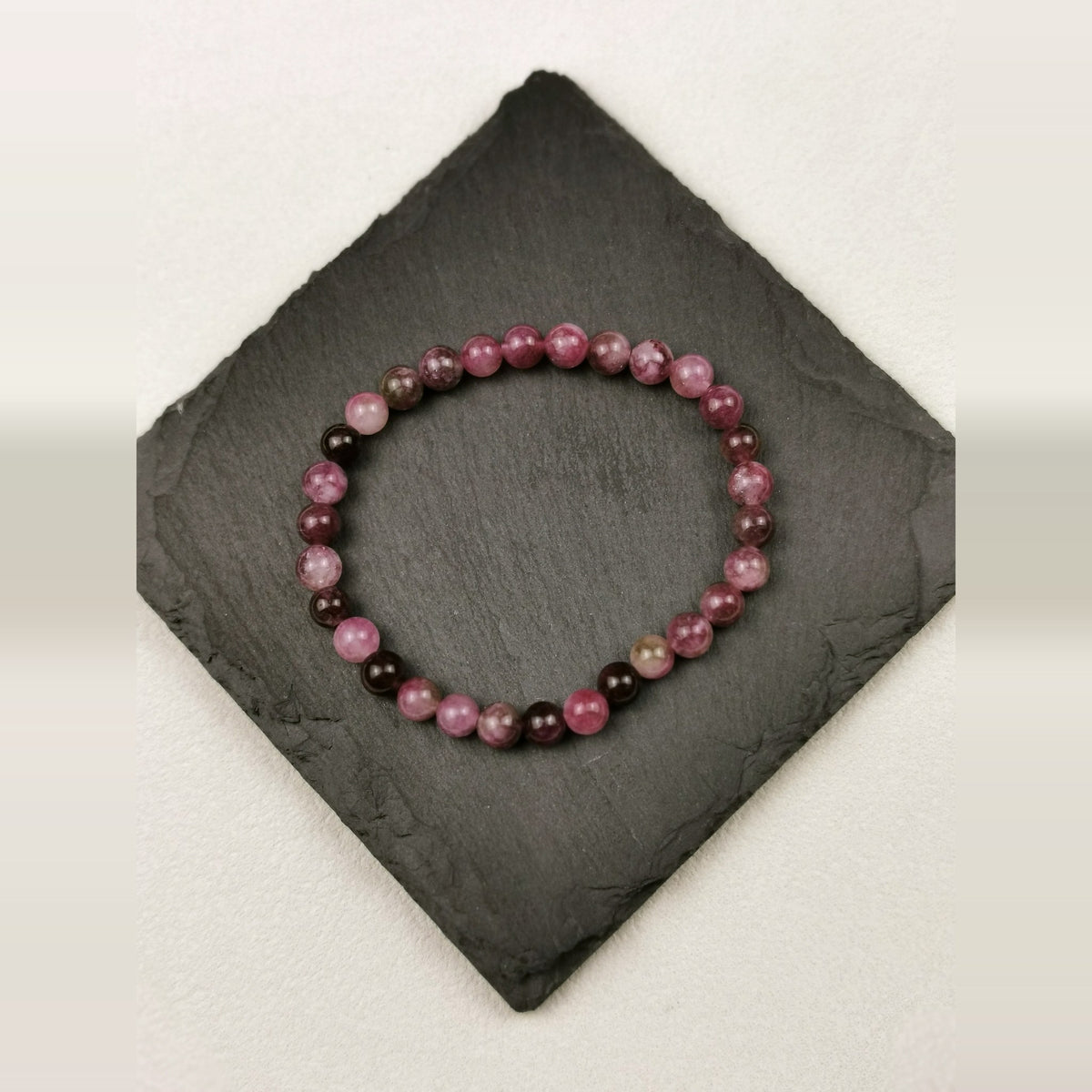 Armband aus runden Kirschturmalinperlen in Pink und Beerenrot mit 6 mm auf Schieferplatte