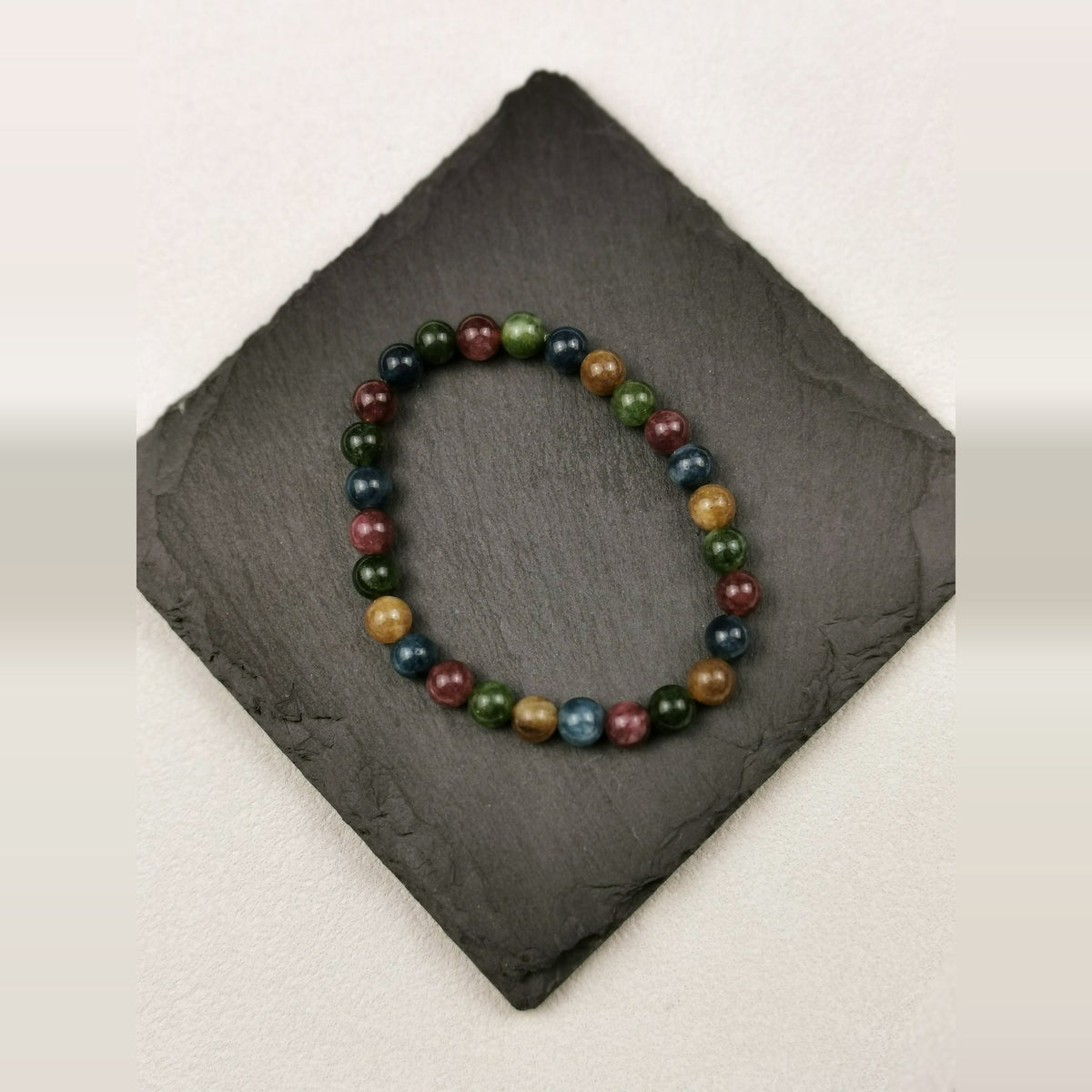 Armband aus buntem Turmalin mit 6 mm Perlen in Grün, Rot und Blau auf Schieferplatte