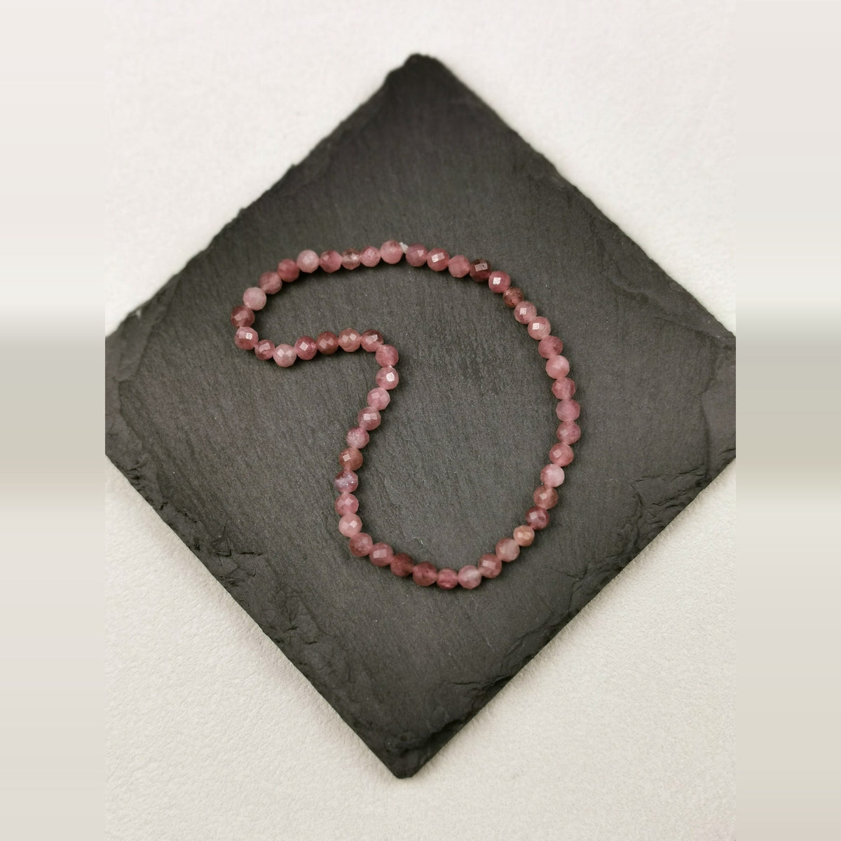 Armband aus facettierten Rubellitperlen in Altrosa mit 4 mm auf Schieferplatte