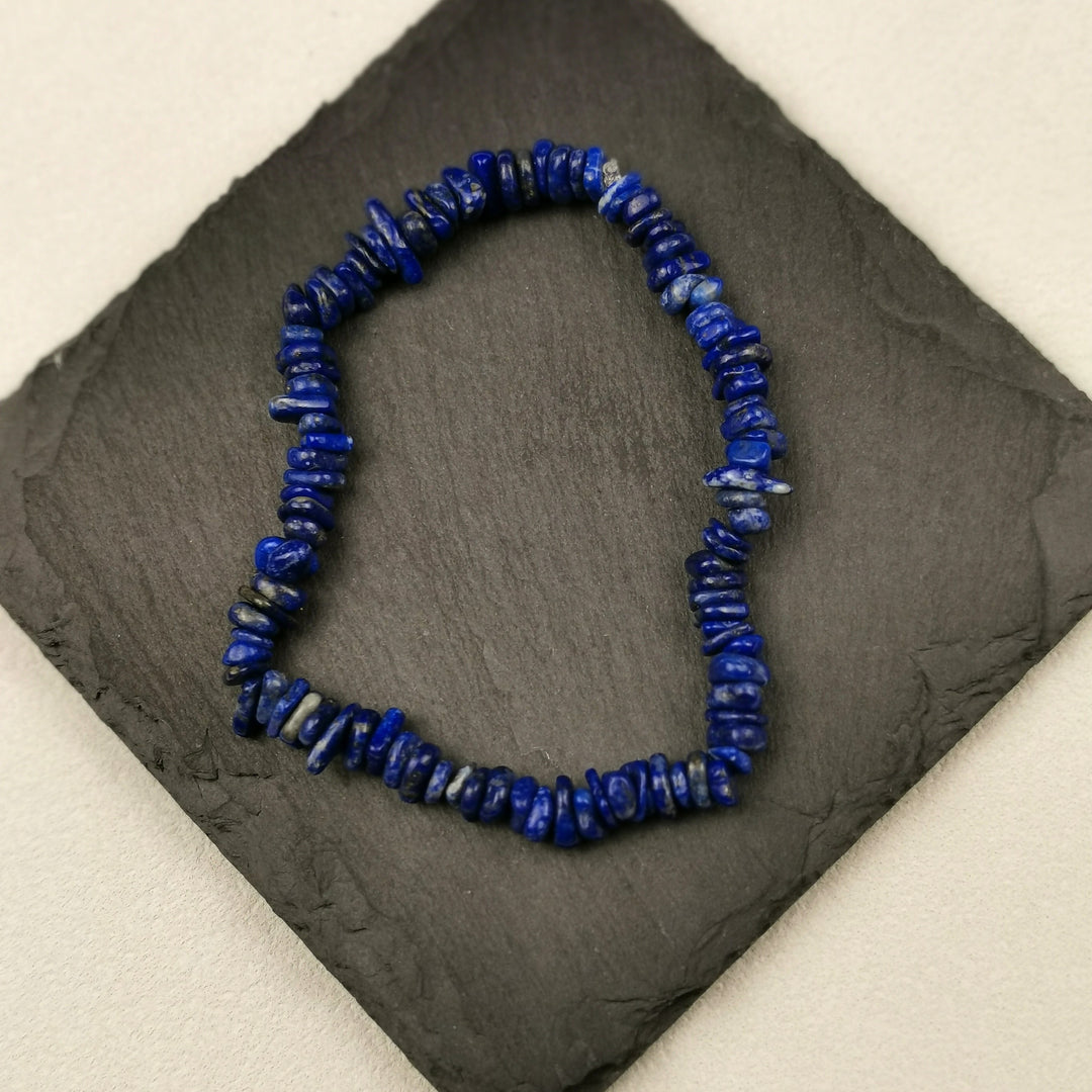 Armband aus Lapislazuli-Splittern in tiefem Blau auf Schieferplatte