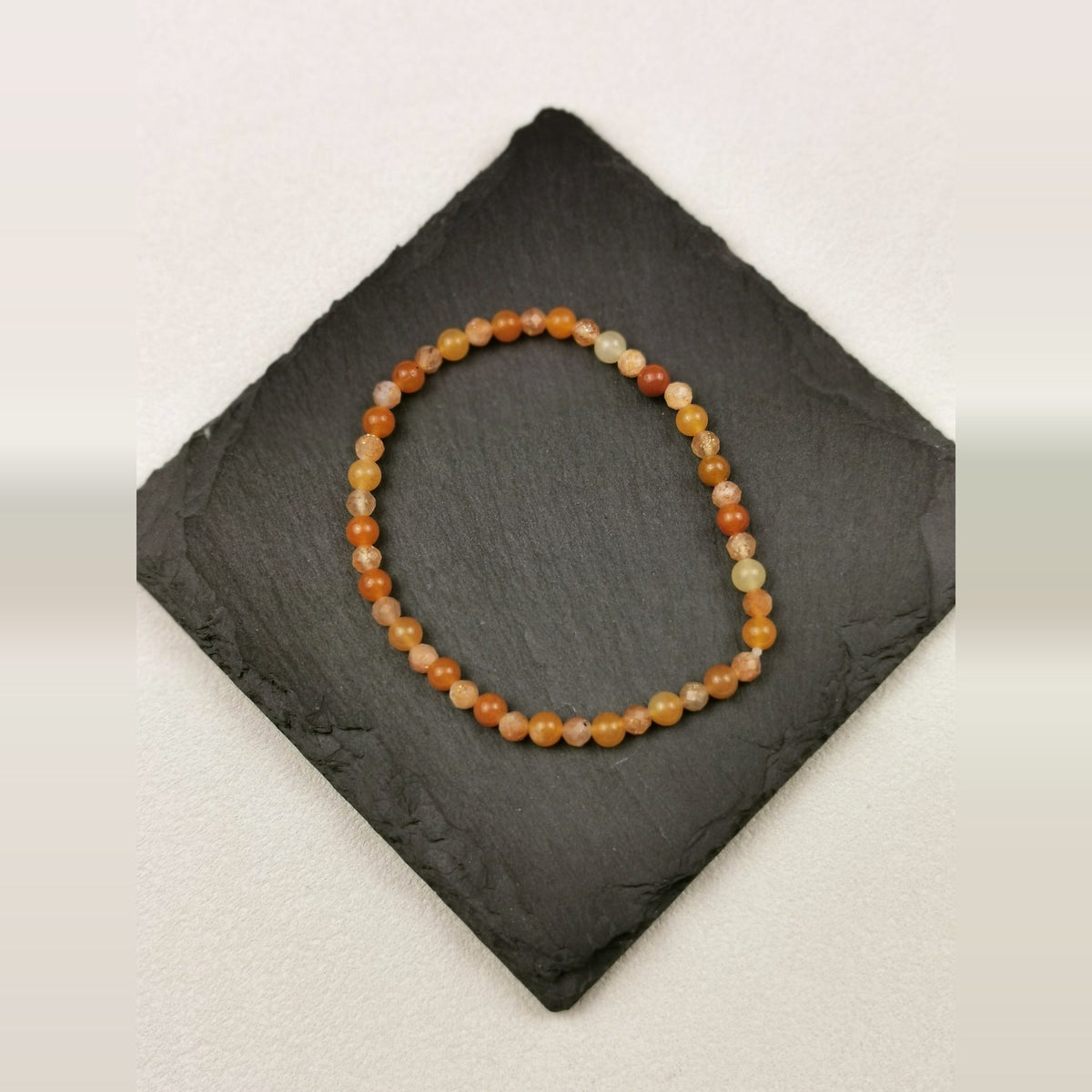 Armband aus facettiertem Sonnenstein und rundem orangefarbenem Aventurin mit 4 mm auf Schieferplatte