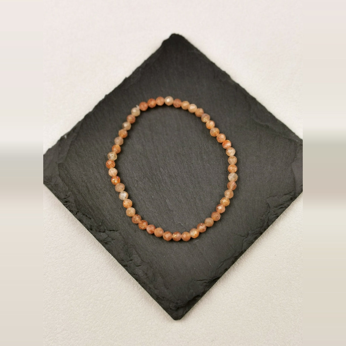 Armband aus facettierten Sonnensteinperlen mit 4 mm auf Schieferplatte