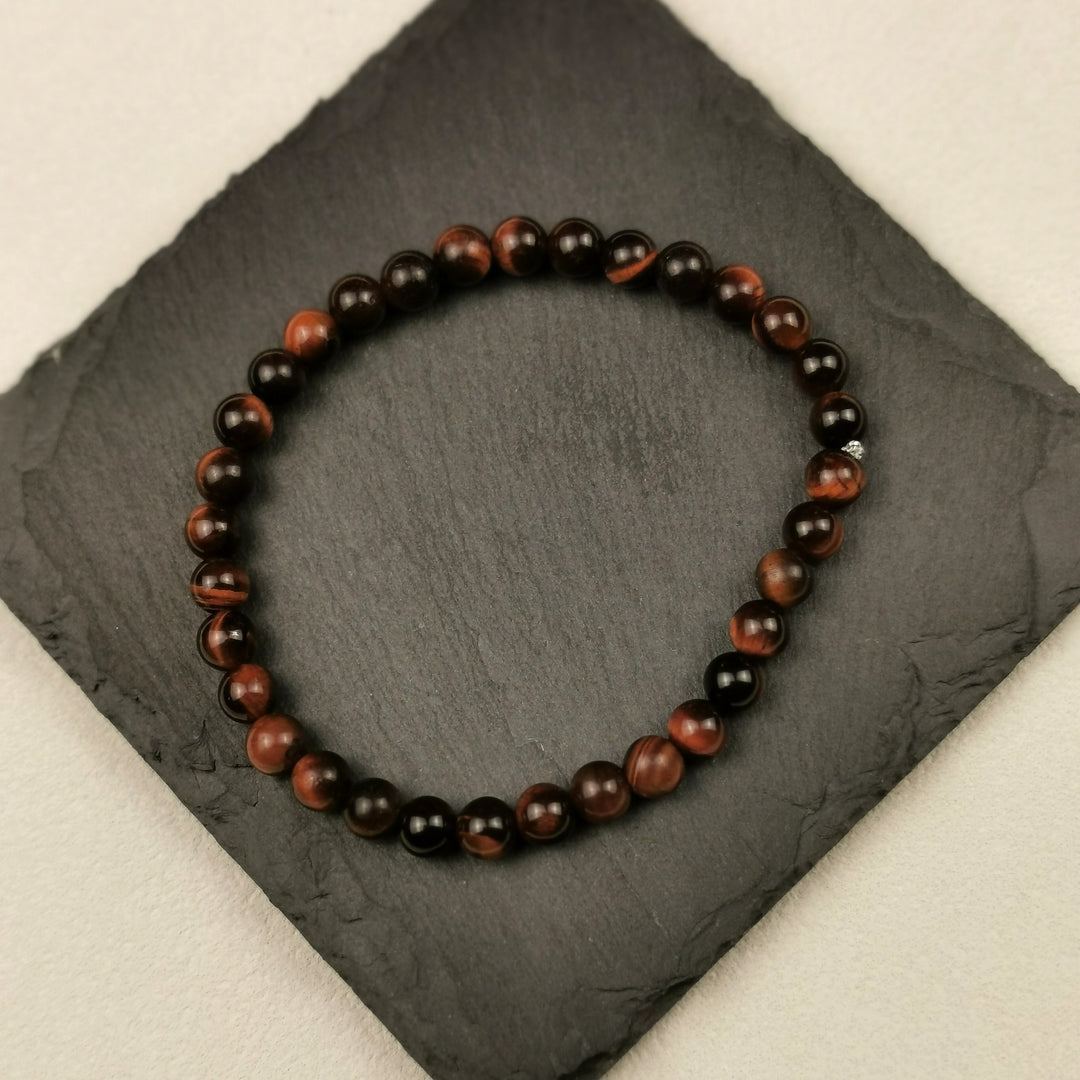 Armband aus runden Tigeraugeperlen in Gold und Braun mit 6 mm auf Schieferplatte