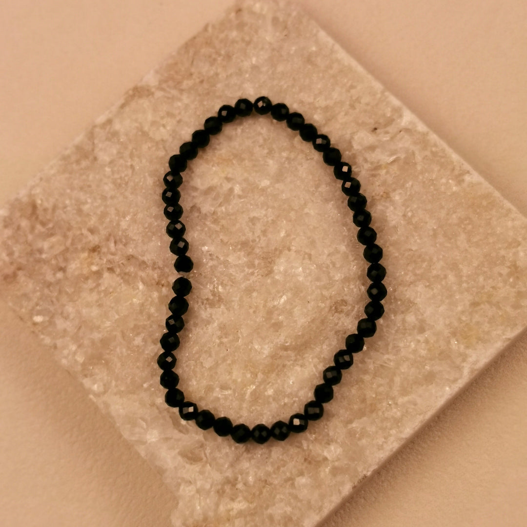 Armband aus facettierten schwarzen Spinellperlen mit 4 mm auf Schieferplatte
